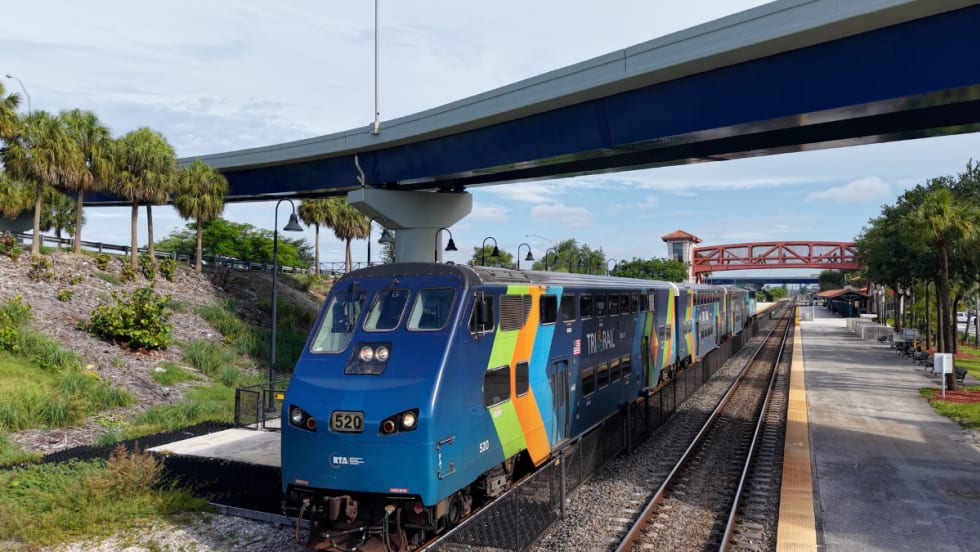A light blue Tri-Rail at a station.