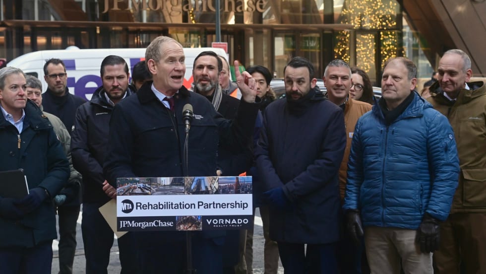 MTA Chair and CEO Janno Lieber stands at a podium in front of a crowd outside the JPMorganChase building.