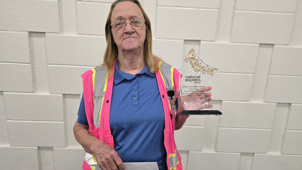 a woman holds an award