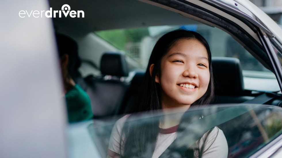 a girl sits in the backseat of a passenger car