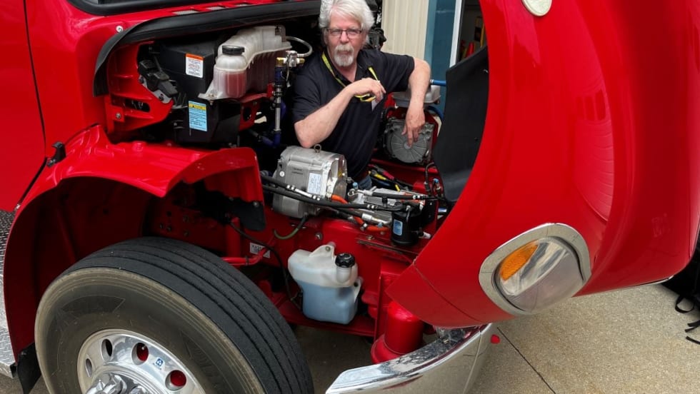 HDT equipment editor Jim Park in the engine bay of a Freightliner truck.