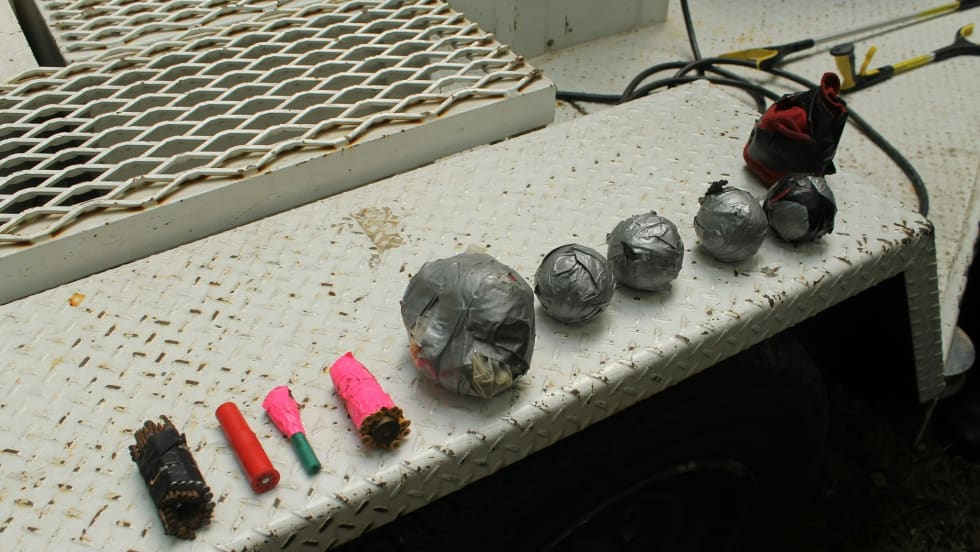 Assorted metal objects, electrical components, and colored tubes on industrial surface