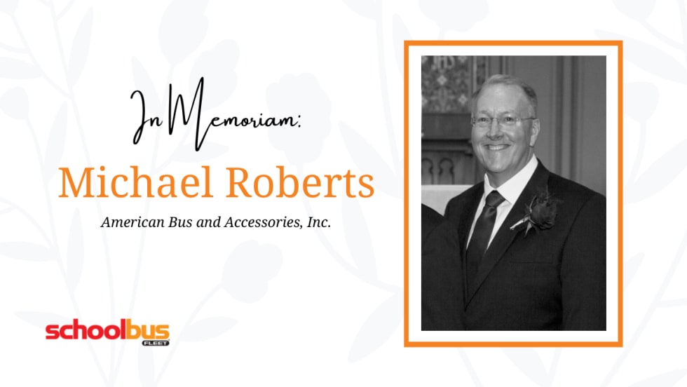 a black and white photo of michael roberts against a white flowery background with text that says "In memoriam Michael Roberts"