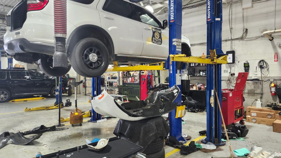 A white Dodge Durango Pursuit is pictured on a blue Rotary lift.