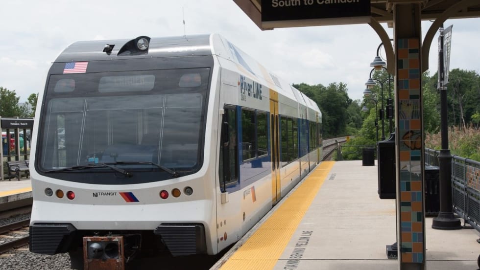 A white NJ TRANSIT River Line rail car at a station.