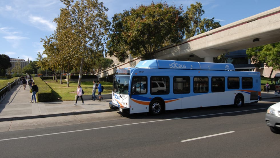 A blue OCTA transit bus at a bus stop.
