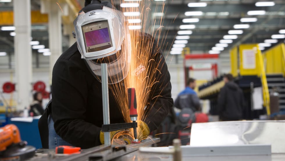 A worker cutting metal.