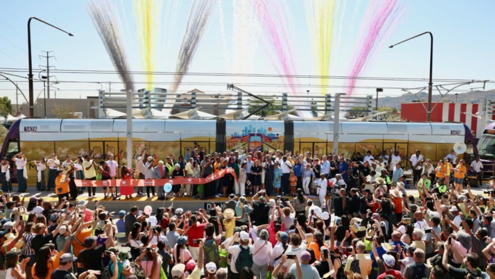 A community ribbon-cutting ceremony with fire works in the background.