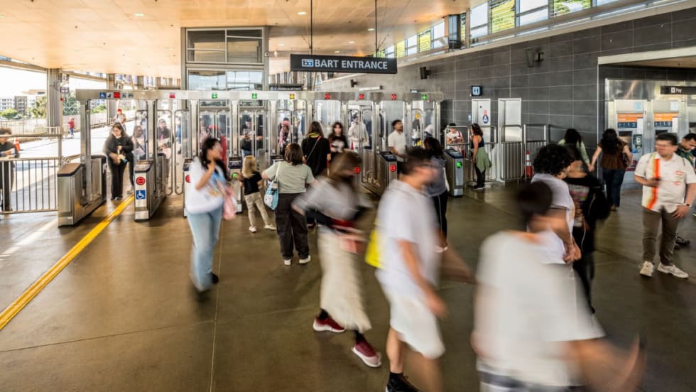 Riders pass through a BART entrance.