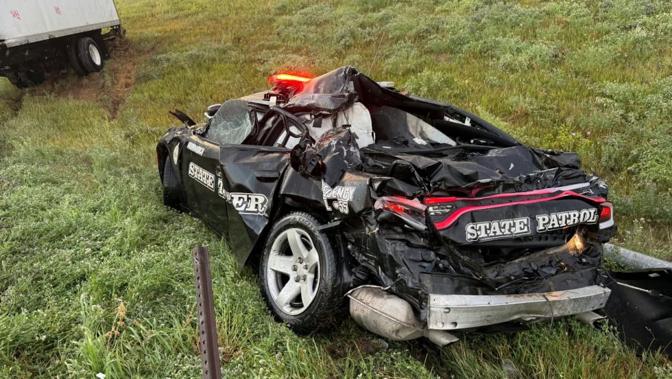 Severely damaged State Patrol police car crashed on grassy roadside
