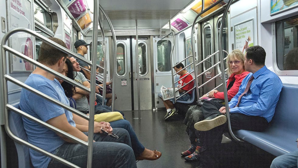 Passengers sitting inside a subway car.