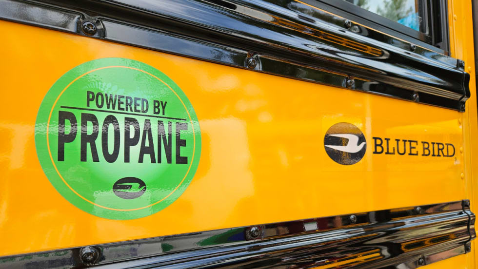 An up-close side image of a Blue Bird with a green graphic that says "Power By Propane."