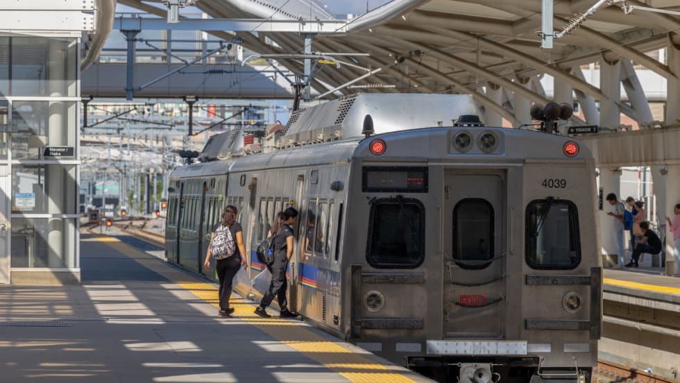 Passengers at a station boarding an RTD train. 