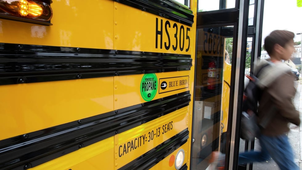 a boy deboards a propane school bus