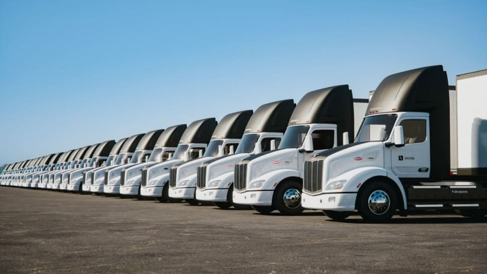A row of new Peterbilt Model 579EV electric trucks.