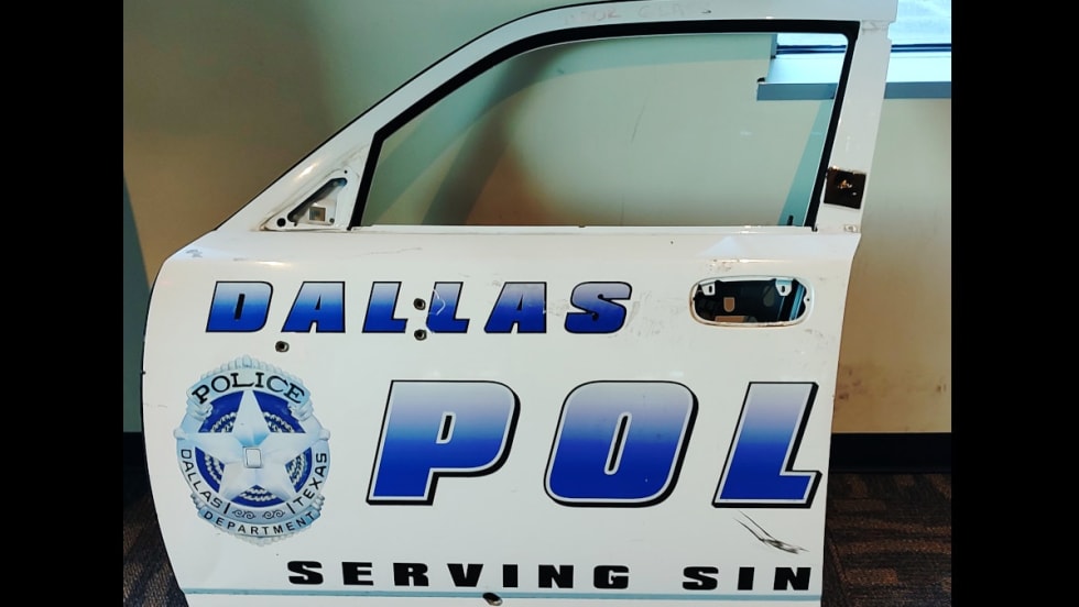 On display on the second floor is the door of a patrol car that was struck by gunfire during the 2015 attack on police headquarters by a man in an armored van.[|CREDIT|]