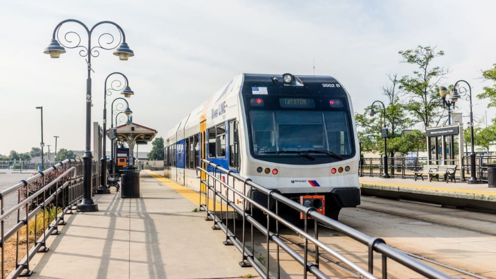 An NJ TRANSIT River LINE rail vehicle at a station.