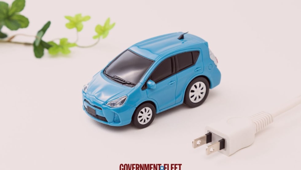 Small blue car with a green leaf and an electric plug.