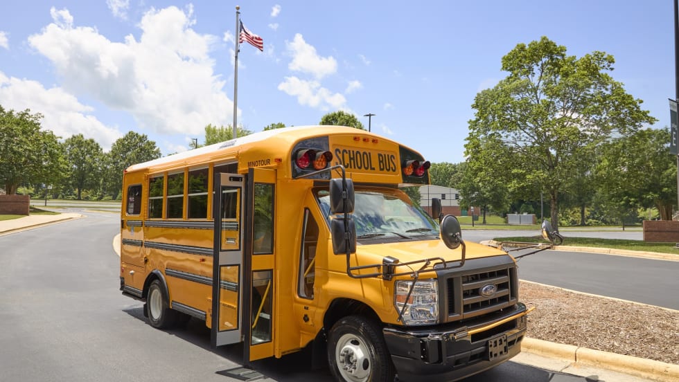 a thomas built type a minotour school bus is shown parked outside on a sunny day