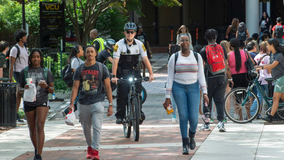 An officer rides an e-bike through the campus of Virginia Commonwealth University.