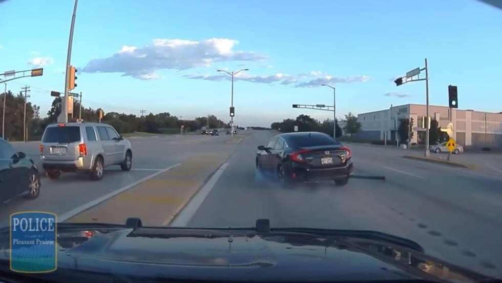 Police dashcam view of intersection with traffic and vehicles