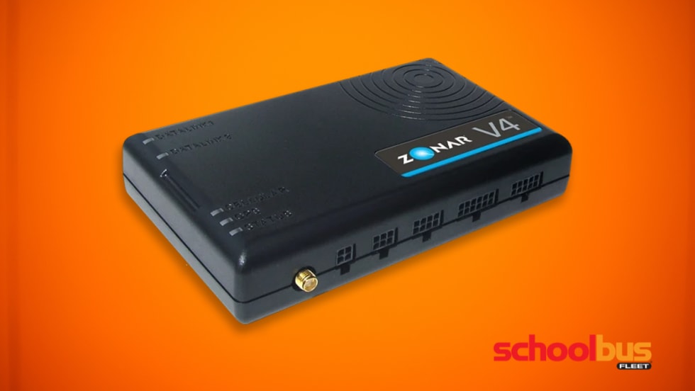 Black Zonar V4 telematics device shown on an orange background, a rectangular fleet telematics unit with status indicator lights and connection ports used in commercial vehicles to collect operational and emissions data.