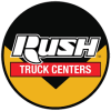 Rush Truck Centers logo featuring bold white Rush text above a red banner with Truck Centers lettering, inside a black and gold circular design