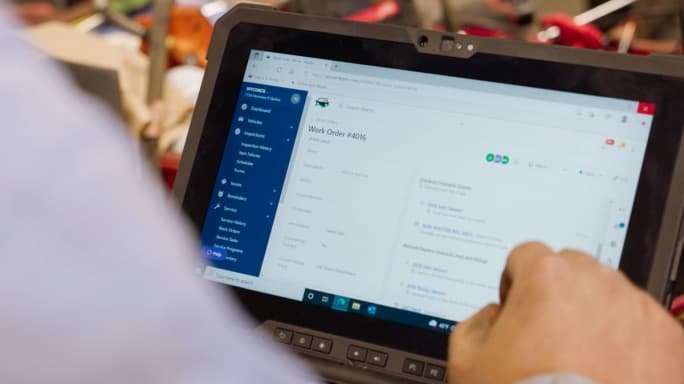 An individual looking at a Fleetio work order on a tablet.