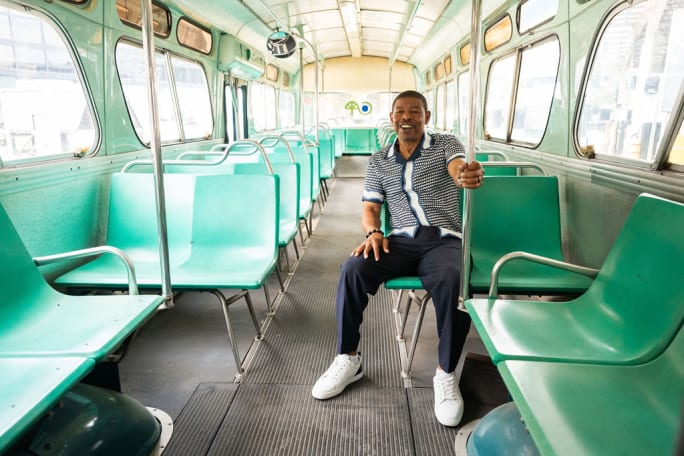 Muggsy Bogues sits inside a vintage CATS transit bus.