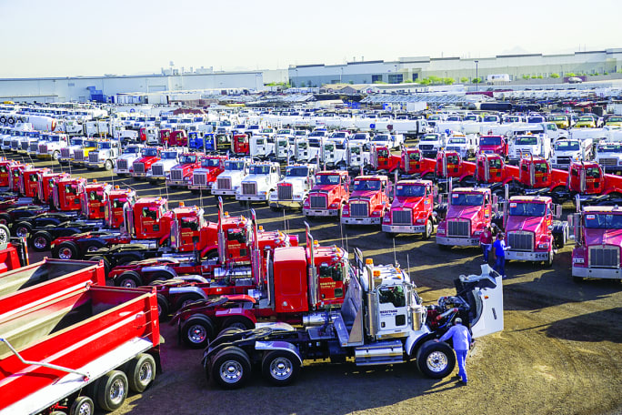 Large auction yard filled with work trucks and vocational vehicles prepared for remarketing and resale through live and online auctions.