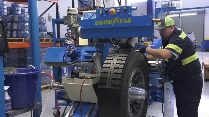 A technician working through the precure process on a retread tire