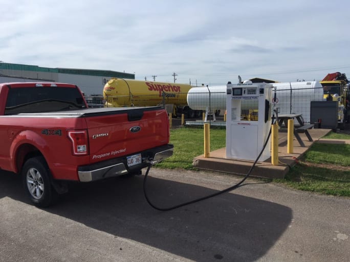 A red pickup truck being refueling with propane autogas
