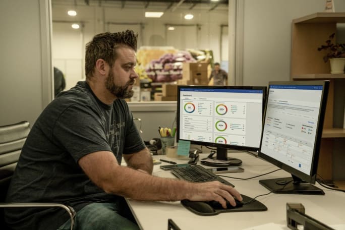 Man at desk looking at Ford Pro dashboards 