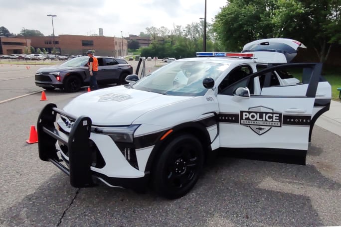 A white police SUV, with a push bar and black wheels.