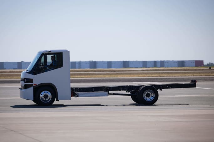 Profile photo of a truck chassis with a white cab passing in front of the camera from right to left.