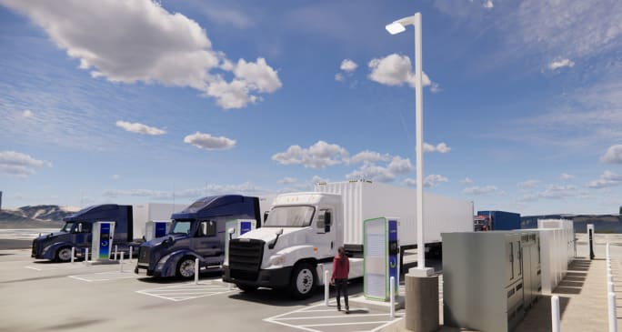 Three trucks parked at charging stations