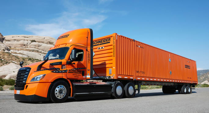 Orange Schneider tractor pulling orange intermodal container