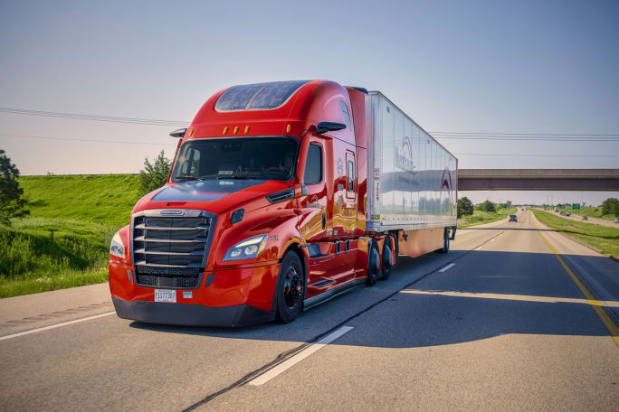 Red Nussbaum tractor-trailer on the highway showing extensive aerodynamic features.