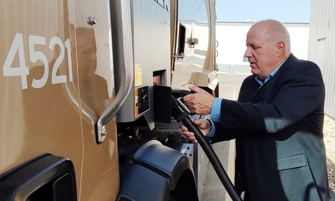 man plugging an EV charger into an electric truck