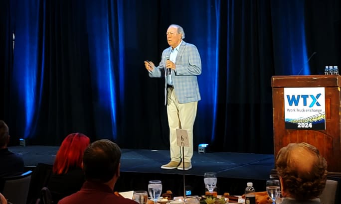 Attorney in business attire speaking on a stage