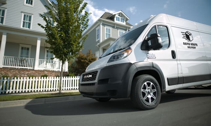 Delivery van parked in front of homes.
