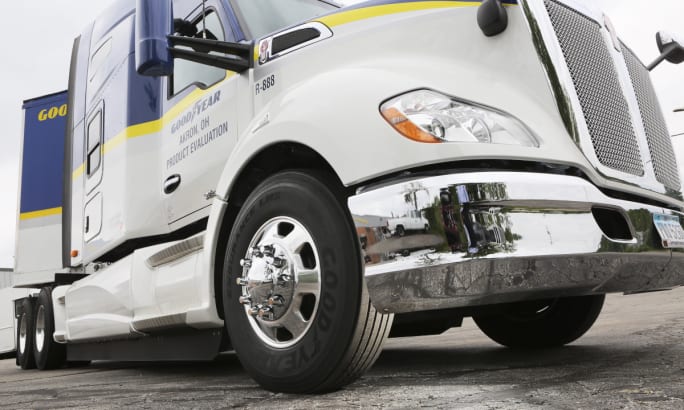 low angle photo of the front right tire on a tractor trailer