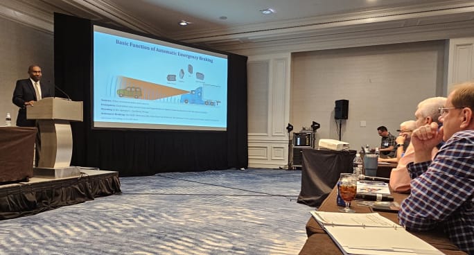 A man stands at a podium and presents to a crowd