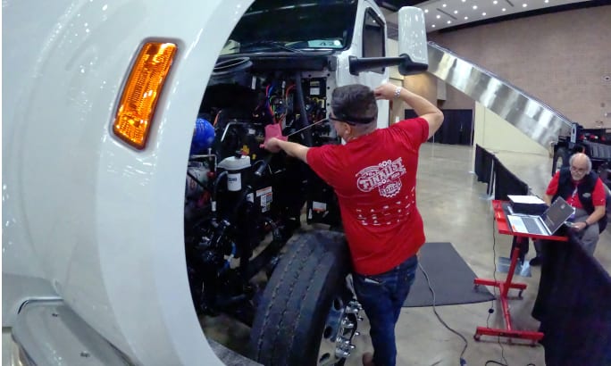 Truck technician checks fluids in a heavy-duty truck.