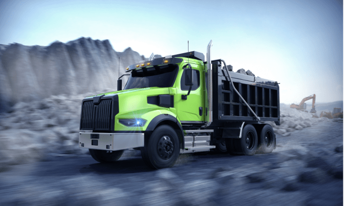 Photo of a dump truck painted bright green driving in a quarry.