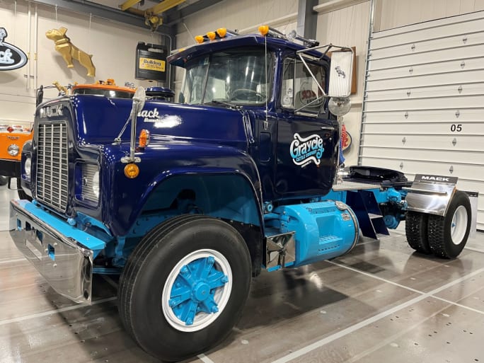 Blue Mack truck parked inside museum.