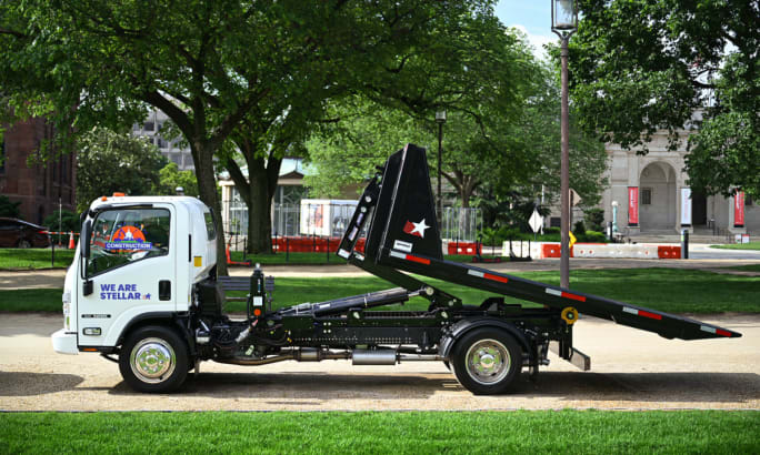 White hooklift truck on display.