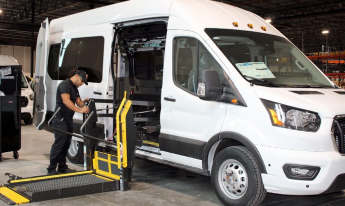 Man installs wheelchair lift into a van.