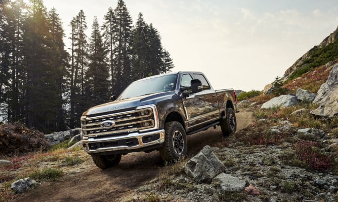 Black Ford Super Duty pickup truck driving off road.
