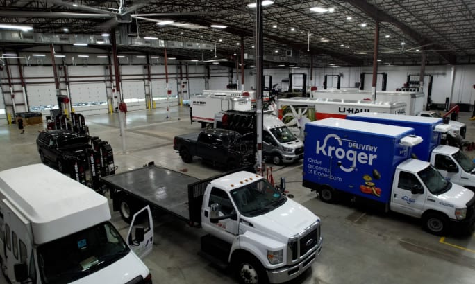 Interior of a Ford Pro Elite Commercial Service Center with work trucks and vans inside large service bays.